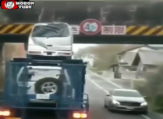 Video :An automobile transporter truck attempts to cross an extremely low bridge